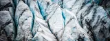 A detailed, close-up photograph of a glacier's surface, showing sharp white peaks, vibrant blue ice in deep crevasses, and layers of dark sediment. clear and transparent commitment to GDPR compliance.
